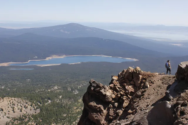 Hiker near the summit of Mount McLoughlin, with Fourmile Lake and Pelican Butte, Sky Lakes Wilderness (2015-08-15)
