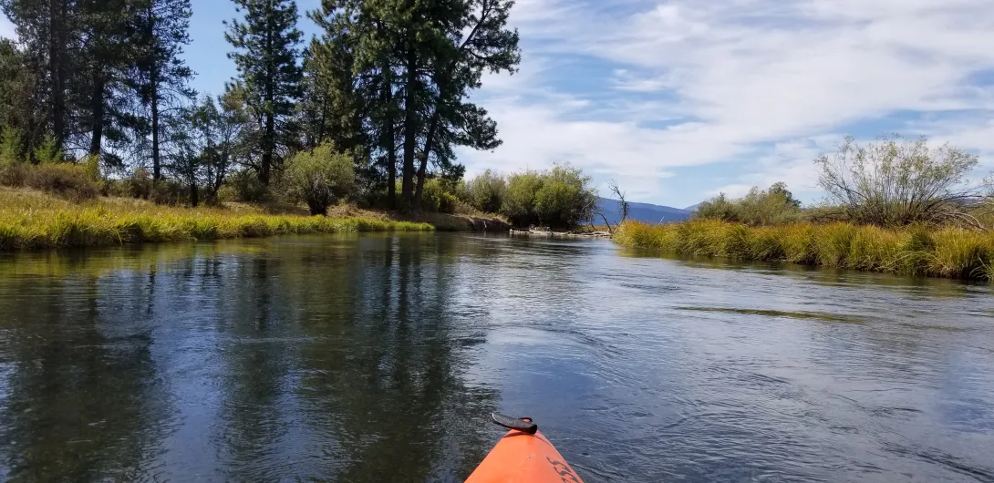 Clear, calm water on the Upper Wood River seen from a kayak